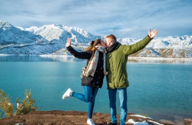 Karlı dağların arkasında mutlu genç bir çift