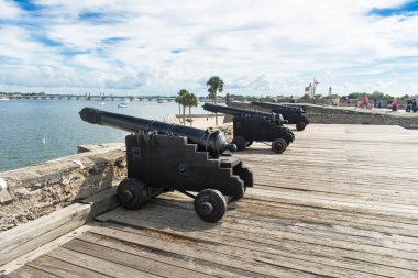 İspanyol sömürge topları eski bir İspanyol kalesinin tepesinde, bulutlu bir gökyüzü ve palmiye ağaçları, St Augustine, Florida, ABD.