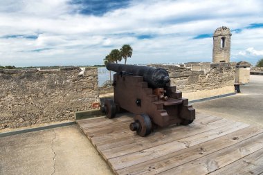 İspanyol sömürge topları eski bir İspanyol kalesinin tepesinde, bulutlu gökyüzü ve palmiye ağaçları, St Augustine, Florida, ABD.