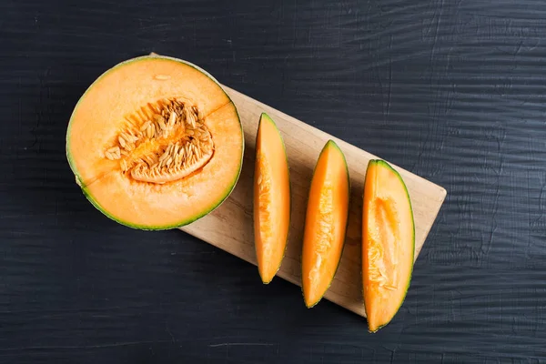 slice of Japanese melons, orange melon, or cantaloupe melon with seeds  on black background