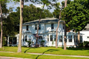 Dunedin, Florida, ABD, 28 Eylül 2021. Rahat bir Amerikan tarzı ev. Palmiye ağaçları, çiçekler ve mavi gökyüzünün altında yeşil bir çimen.