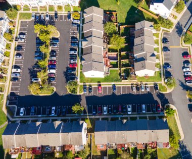 Otoparktaki arabalarla banliyödeki apartman bölgesinin yukarıdan görüntüsü.