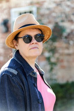 Güzel bir kadın sokakta yürüyor gözlük, şapka ve ceket takarak