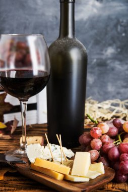 Şarap şişesi, üzüm, peynir, bir bardak kırmızı şarap. Kopyalama alanı ile