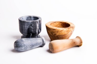 Beyaz arka planda taş ve ahşaptan yapılmış iki havan topu..