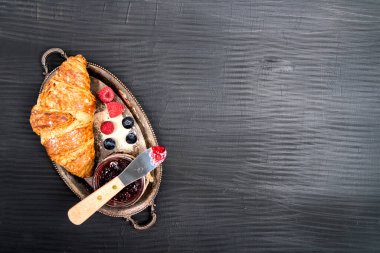 Kahvaltıda kruvasan ve ahududu reçeli. Yukarıdan bak. Metin için boşluk.