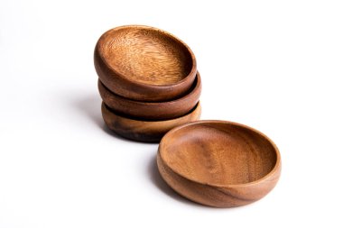 Beyaz arka planda ahşap sofra takımları, kaseler ve stupa