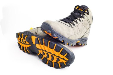 Beyaz arka planda zencefil tabanlı gri yürüyüş botları..