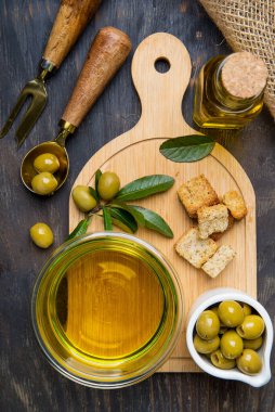 Kesme tahtasında zeytin ve zeytin yağı. Yukarıdan görünüm.