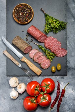 Siyah taşta domatesli salam, biber ve sarımsak. Yukarıdan görüntüle.