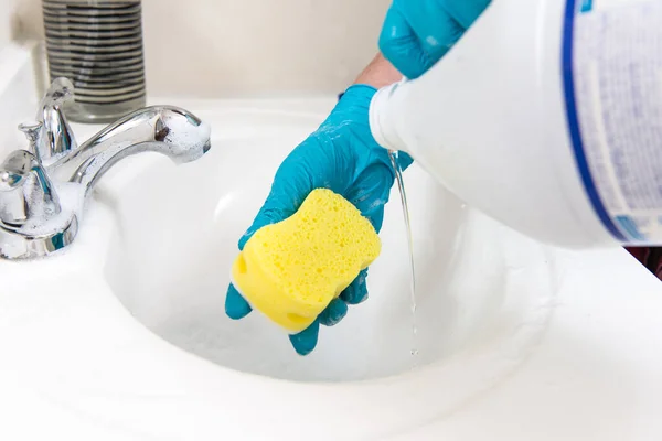伝染病だ 手袋の女性は消毒剤でシンクをきれいにします 男の手は浴室を洗っているか掃除している — ストック写真