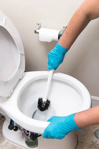 Woman cleaning the toilet bawl with a brush Cleaning the bathroom and toilet of own house or restaurant , hotel .