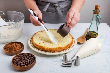 Kadın şef pasta ve krema yapmak için pasta katmanları hazırlar..