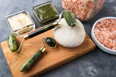 Yüz masajı için Jade Roller. ve kişisel bakım için doğal malzemeler. Ovalama, maske, avakado, biberiye, okaliptüs kremi.