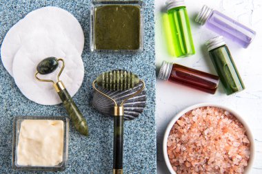 Cosmetic rollers and glass bottles with cosmetic serum and lotion on marble table. Facial skin care. View from above.