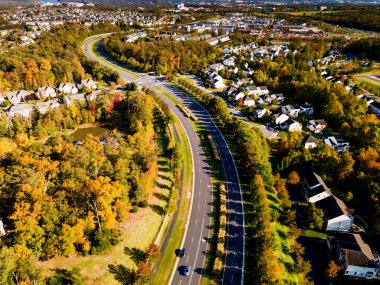 Küçük bir kasabanın yerleşim yerinin panoraması, dolambaçlı bir yol boyunca yeşil bir ormanın içinde..