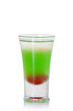 Yeşil alkollü shot bardağı, beyaz arka planda İrlanda kreması, likör.