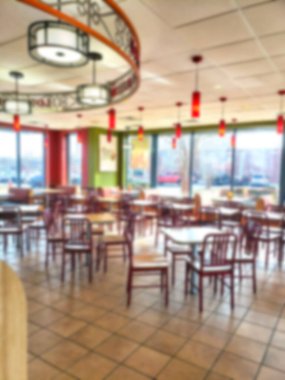 Boş bir restoranın arka planında bulanık pencerelerden gelen doğal ışık....