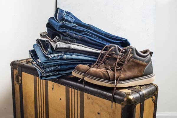 Alte Schuhe Und Ein Stapel Blue Jeans Liegen Auf Einem — Stockfoto