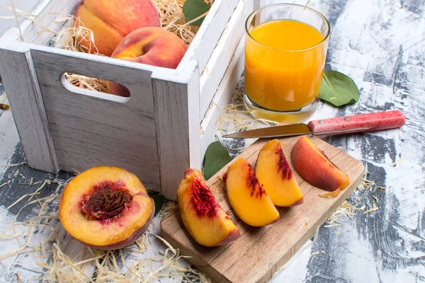成熟的蜜桃片 一盒桃子和蜜桃汁 背景浅 — 图库照片