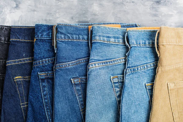Jeans Diferentes Tonos Encuentran Sobre Fondo Gris Lugar Para Texto — Foto de Stock