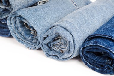 Beyaz arkaplanda çeşitli kot pantolon koleksiyonu.