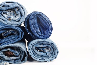 Beyaz arka planda farklı bir kot pantolon yığını. Metni kopyala.