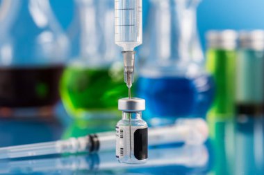 Covid-19. Aşı şişesi ve aşıyla dolu şırınga. Metin kopyalanıyor.