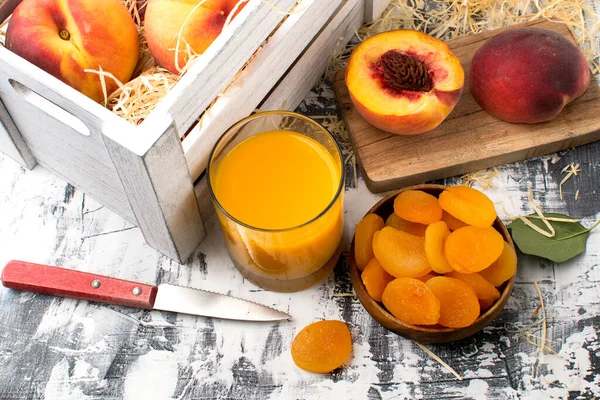 一杯桃果汁 干果和成熟的桃子放在白桌上 — 图库照片