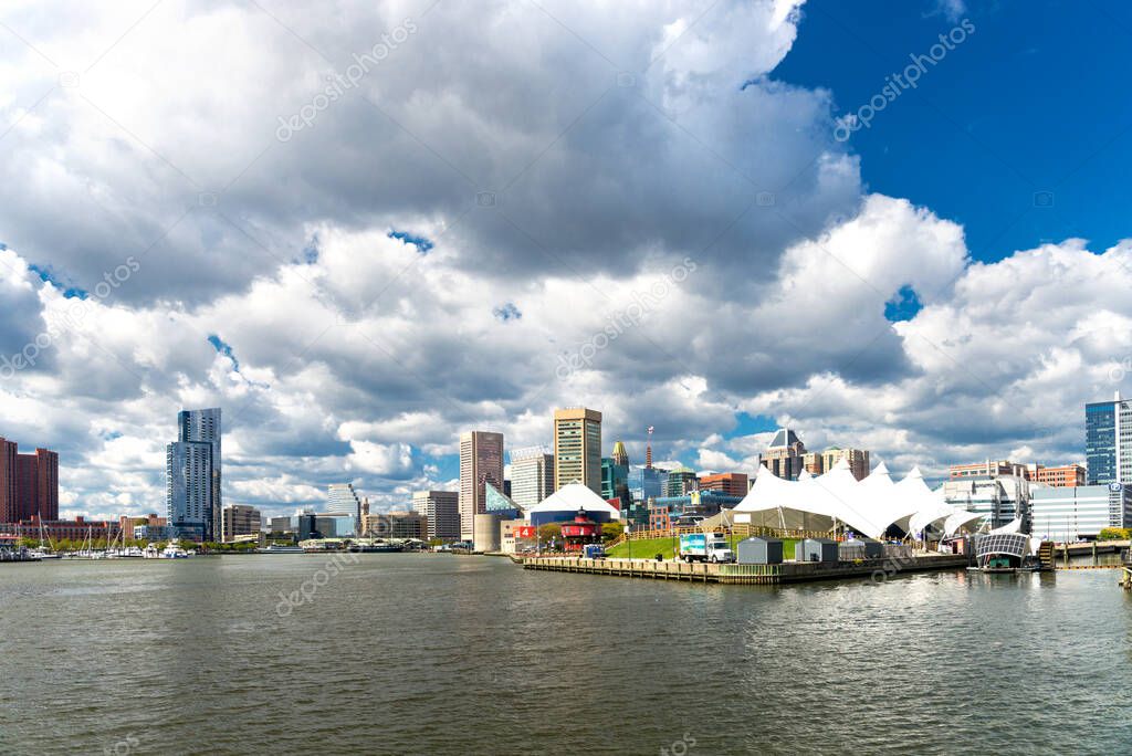 Panoramic view of the Baltimore Pier and Inner Harbor and skyscrapers against a blue sky with low clouds. State of Maryland, USA
