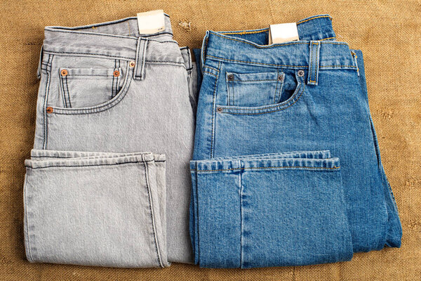 Gray and blue jeans on a background of old burlap. View from above.