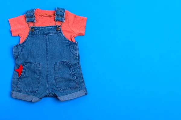 Ubranka Dla Dzieci Niebieskim Tle Dżinsowy Kombinezon Czerwony Body Odbiór — Zdjęcie stockowe