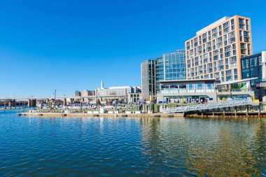 Güneşli bir sonbahar gününde Washington Riverfront. Açık gökyüzü körfeze yansıyor.