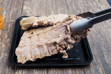 Pişirmek için hazırlanmış bir yemek tepsisinde haşlanmış et. Domuz pirzolası. Yakın plan.