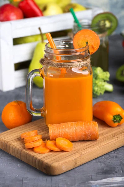 Morotsjuice Ett Glas Och Morotsbitar Skärbräda Mot Bakgrund Låda Med — Stockfoto