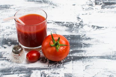 Gri bir masada domates suyu ve domates suyu. sağlıklı gıda konsepti.