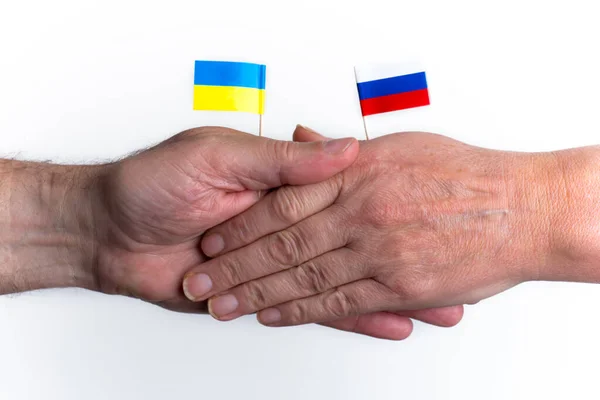 Two hands with flags of russia and ukraine Handshake symbolizes truce, partnership and cooperation. Concept of business, communication, politics, unity, friendship, world help