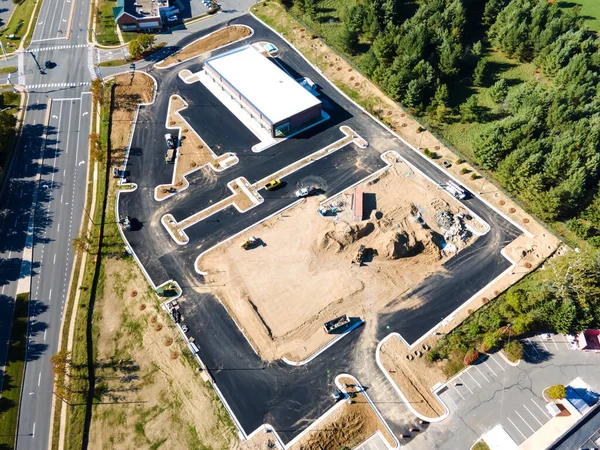 Yol boyunca bir ticaret platformu inşa etmek. Asfalt kaldırım ve inşaat makineleri. Yukarıdan görüntüle.