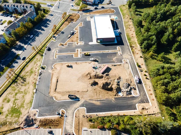 Yol boyunca bir ticaret platformu inşa etmek. Asfalt kaldırım ve inşaat makineleri. Yukarıdan görüntüle.