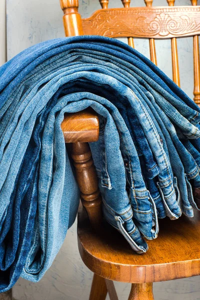 Pila Vaqueros Azules Encuentra Parte Posterior Una Silla Madera Primer — Foto de Stock
