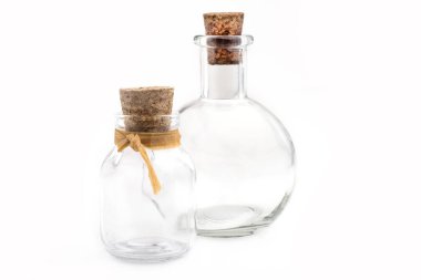 Beyaz arka planda tıkaçlı iki cam şişe..