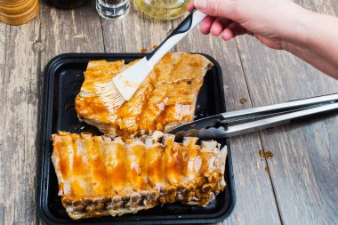  Aşçı sosu pişmiş et parçalarının üzerine döker. Fırında pişirme hazırlığı.