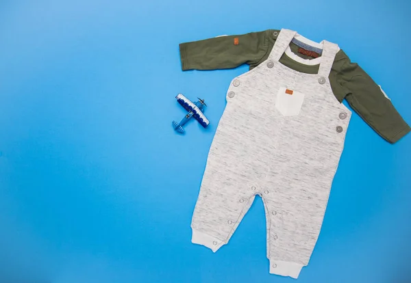 Flat lay composition with cute clothes and place for text on blue background. Children's accessories