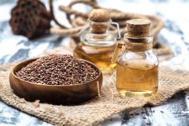 Tahta bir kasede keten tohumu tohumları ve keten tohumu yağı. Sağlıklı gıda konsepti.