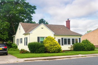  Sahil köyünde manikürlü çimleri olan küçük bir Amerikan evinin dış görünüşü..