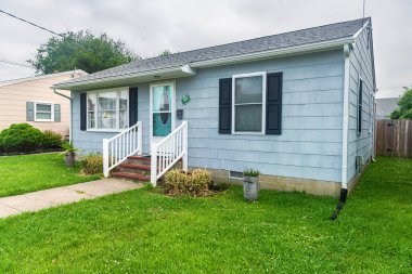  Sahil köyünde manikürlü çimleri olan küçük bir Amerikan evinin dış görünüşü..