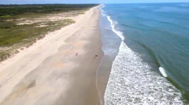 Güzel gel-git dalgalarıyla ıssız bir sahil. Dalgalarda beyaz deniz köpüğü. Kıyı boyunca hareketli deniz manzarası, insansız hava aracı videosu. Atlantik Okyanusu 'nun dalgaları, yüksek gelgit.
