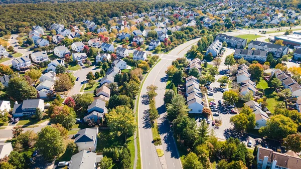 Aerial view of upscale residential area, gated community street real estate with single family homes. Autumn sunny day.