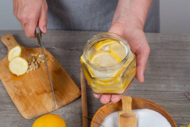 Kadın elleri limon konservesi. Şekeri limon kavanozuna dök.