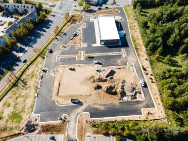 Yol boyunca bir ticaret platformu inşa etmek. Asfalt kaldırım ve inşaat makineleri. Yukarıdan görüntüle.